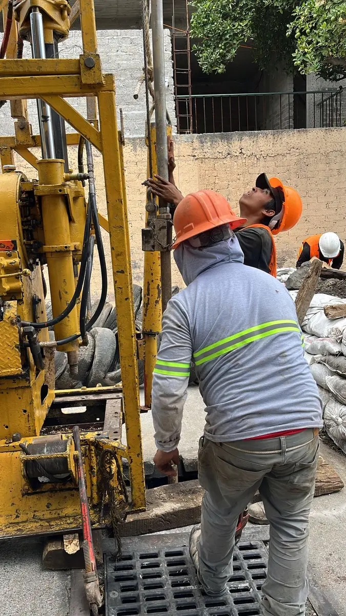 Personal técnico realizando actividades de campo junto a equipo de perforación